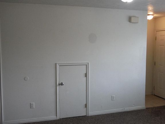 Living Room looking at the half bath door, storage cubby and front door