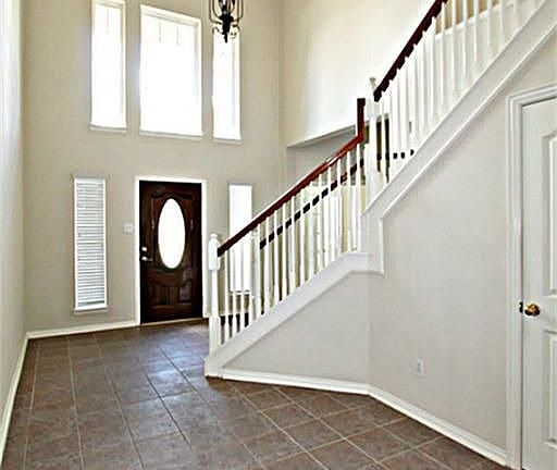 THIS WELCOMING TWO STORY ENTRY COMPLETE WITH AN ART NICHE, TILE FLOORS, CROWN MOLDING, AND A LOVELY 