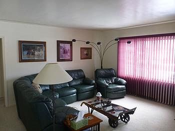 The Living Room has a large picture window and nice detail in the ceiling as well as built-in shelving.  There is wood flooring under the carpet.