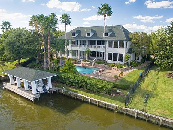 STATELY REAR ELEVATION OF THIS BEAUTIFUL WATERFRONT HOME IN SOUGHT AFTER TAYLOR LAKE SHORES. SITTING ON A NEAR HALF ACRE LOT, THIS HOME OFFERS A BOATHOUSE, 3 CAR GARAGE, 2 CAR PORTE COCHERE, POOL WITH ROCK WATERFALL AND TONS OF AMENITIES INSIDE!
