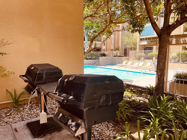 Gas BBQs in pool/jacuzzi area across from unit