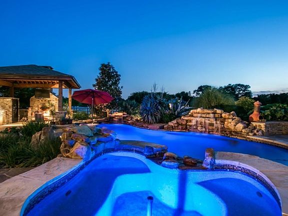 Resort style back yard! Beautiful pool with attached spa, waterfall, swim up bar, and tanning ledge.