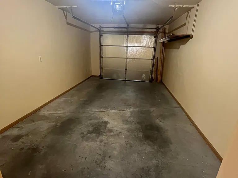 Garage offers a convenient garage door opener. Wall shelving also included for storage.
