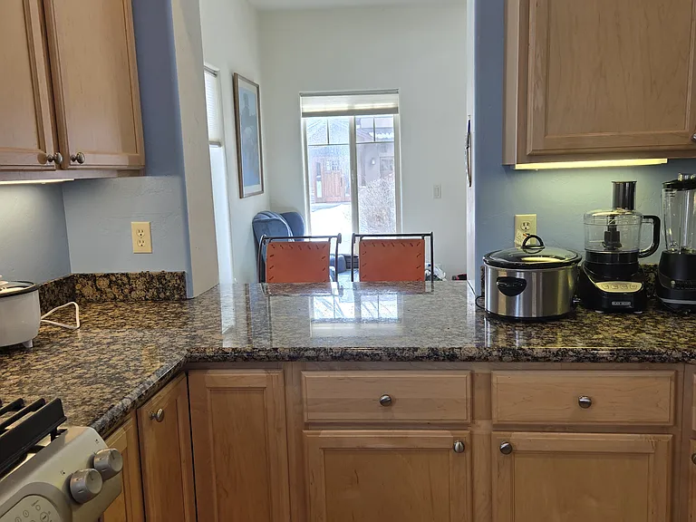 Other side of kitchen with second area for countertop eating. Crockpot, blender, rice cooker, air fryer, and food processor are included