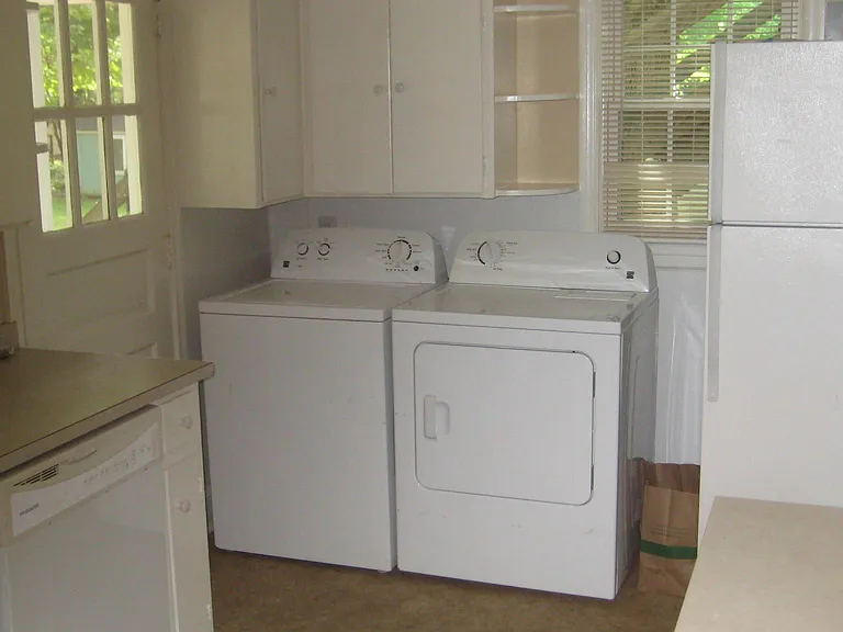 Kitchen showing washer and dryer and refrigerator and back door.
