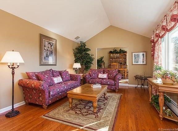 Living room w/ vaulted ceiling open to Dining Room