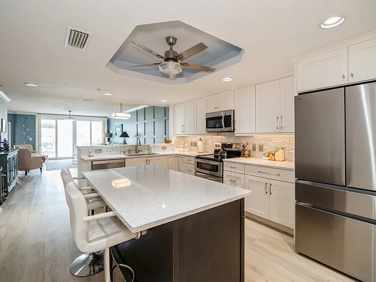 Gourmet kitchen with double ovens, quartz counters, breakfast bar, Bosch dishwasher, fridge with beverage drawer and coffee bar