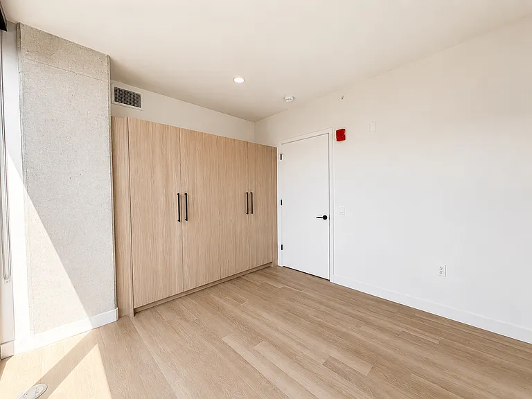 Versatile den at Stead 220 in Fulton Market with a full-wall built-in Italian wardrobe closet, wide-plank flooring, and flexible space for a home office, guest room, or nursery.