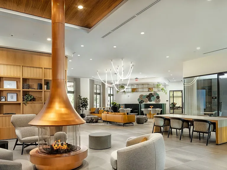 Lobby and resident lounge with fireplace, lounge seating, and coworking spaces