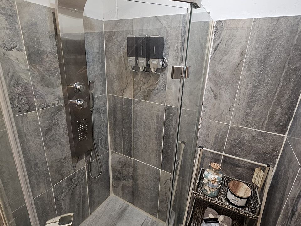 Glass Shower Box with Shower Panel & Tile Throughout