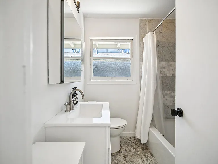 Bright full bathroom with shower and bathtub