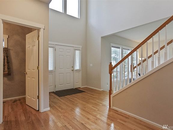This lovely entry features soaring ceilings and large windows to let the light stream in. A powder room sits just off of the entry. 