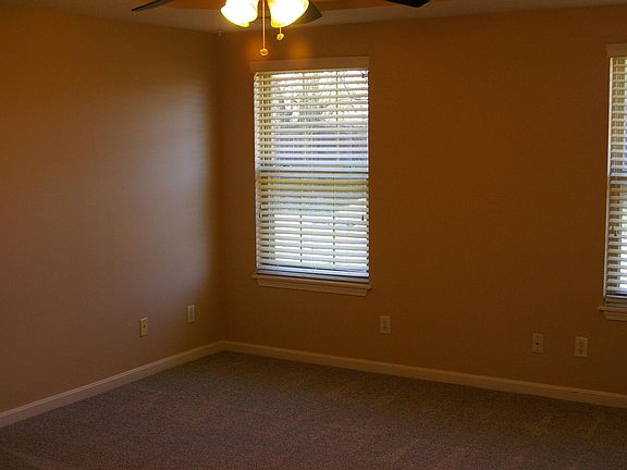Master bedroom with ceiling fan, walk-in closet, and ensuite bathroom.