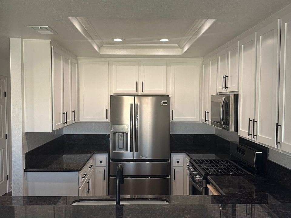 Kitchen with granite countertops, stainless steel appliances, and auto-closing drawers.