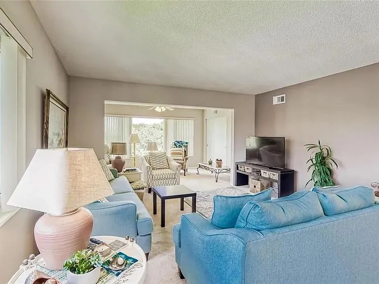 Living room is in the foreground; Florida room is in the background.

 *This unit is unfurnished. All furniture has been removed.