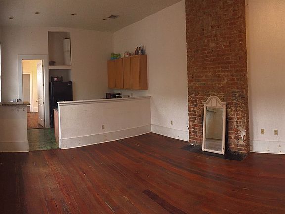 Large living room/kitchen with high ceilings, exposed origin