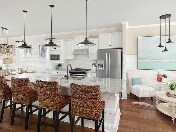 Open kitchen with large center island, tile backsplash, stainless gas appliances seating area to v