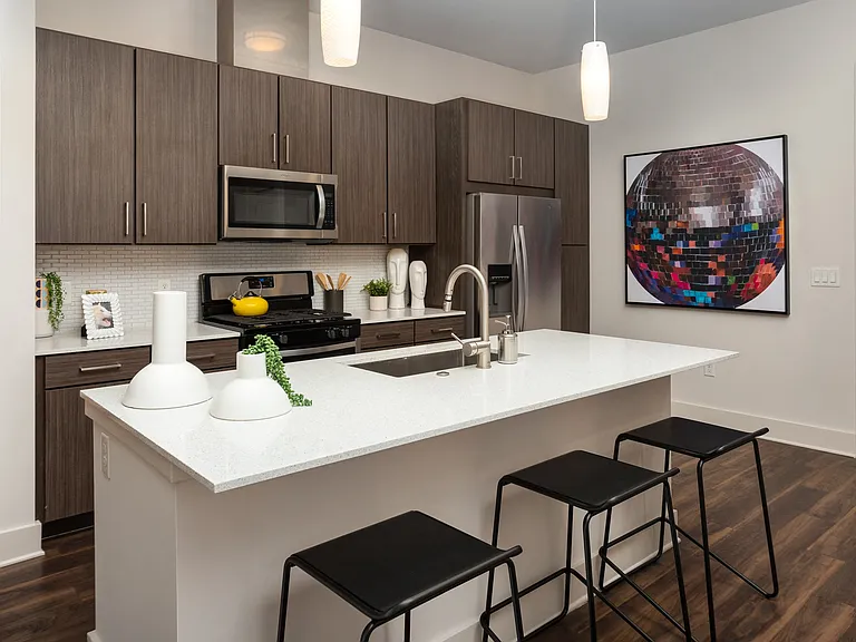 Modern Kitchen with Dark Cabinetry, Open Island, and Vibrant Artwork Accent
