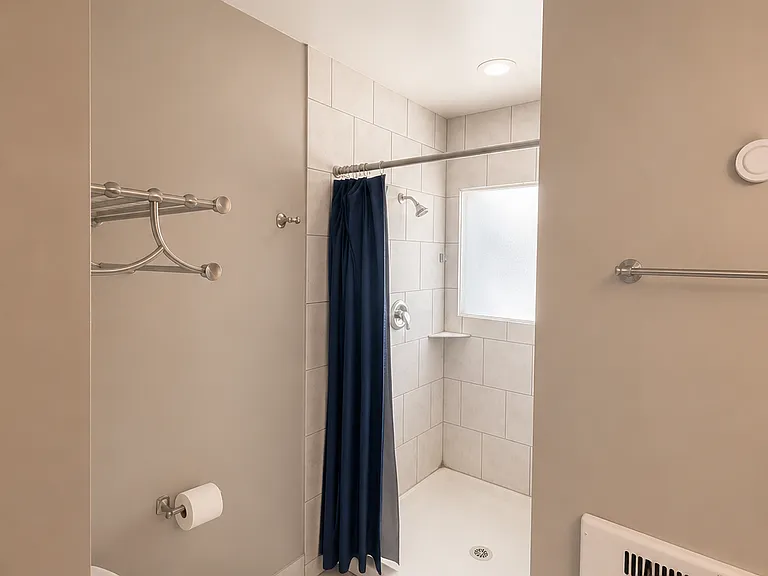 Updated bathroom with modern vanity and heated tile floors.