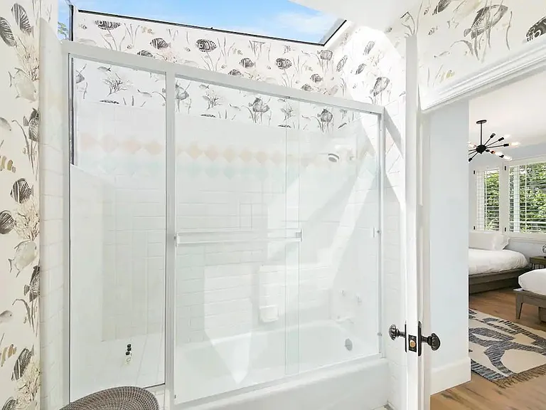 Guest bedroom full bathroom shower and natural skylight.
