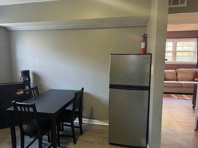 Dining area with medium sized fridge.