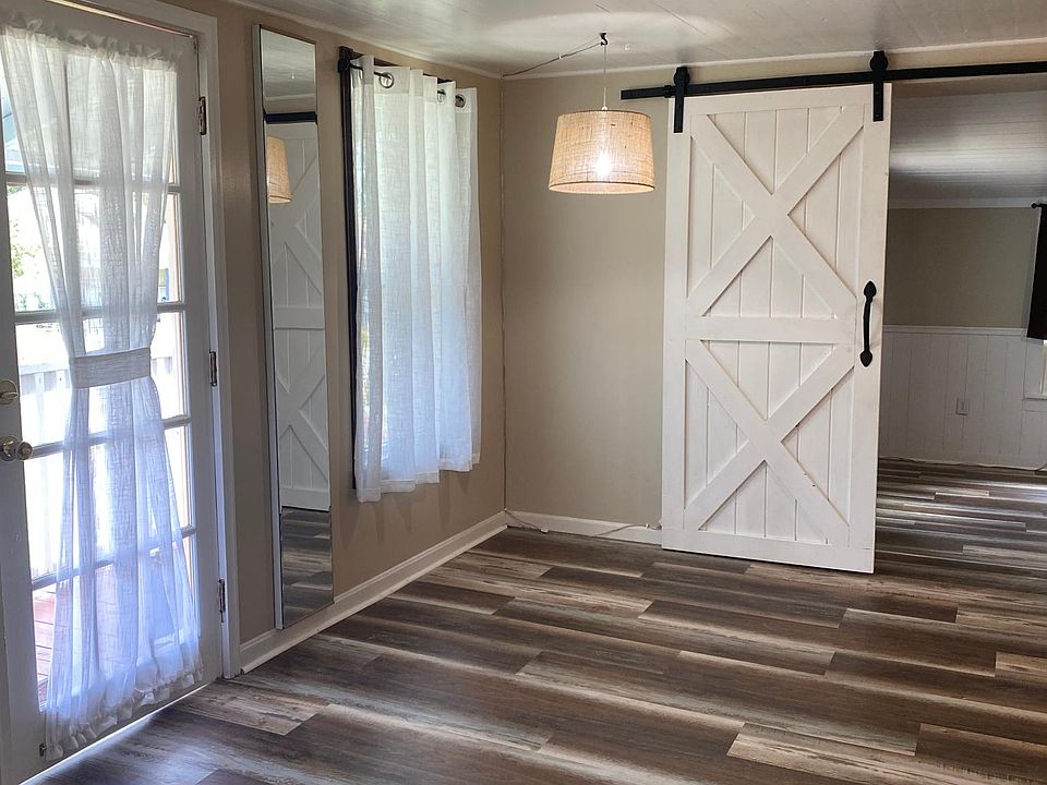Dining room leads to large bedroom with barn door