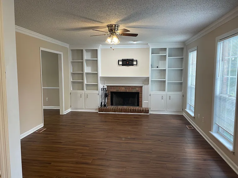 Look to your right and see the large living room with wood burning fireplace and bult in shelving