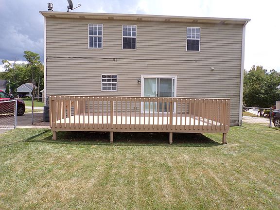 back of the house with a huge deck and fenced in yard