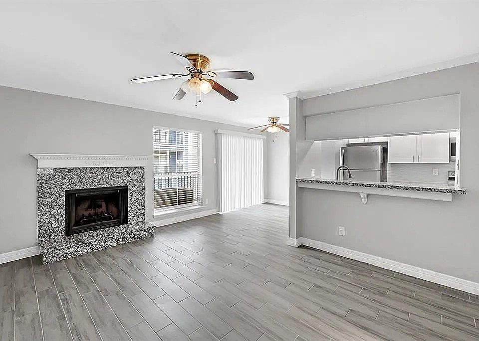Large living area with a fireplace and ceiling fan.