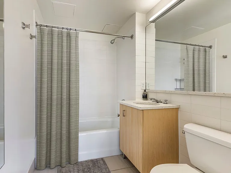Select baths with cream terrazzo countertops, oak cabinetry, and tile flooring