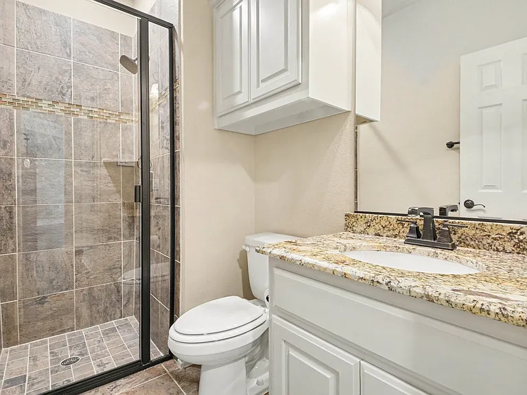 Shower enclosure featuring subway tile with a mosaic accent band and a built-in shelf