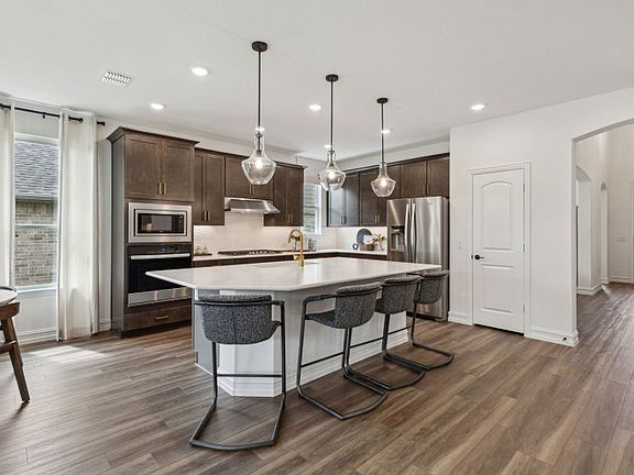 Spacious kitchen with recessed and pendant lighting