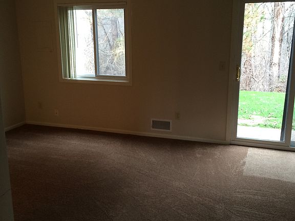 living room with new carpet , with walk out to wooded back y