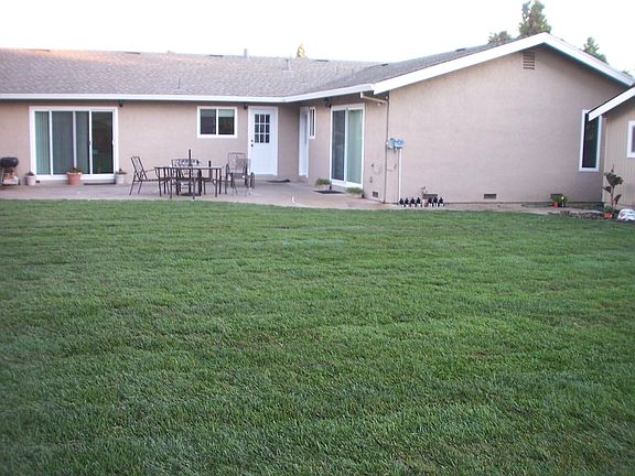 Backyard features a big patio for BBQs, and a spacious grass yard.