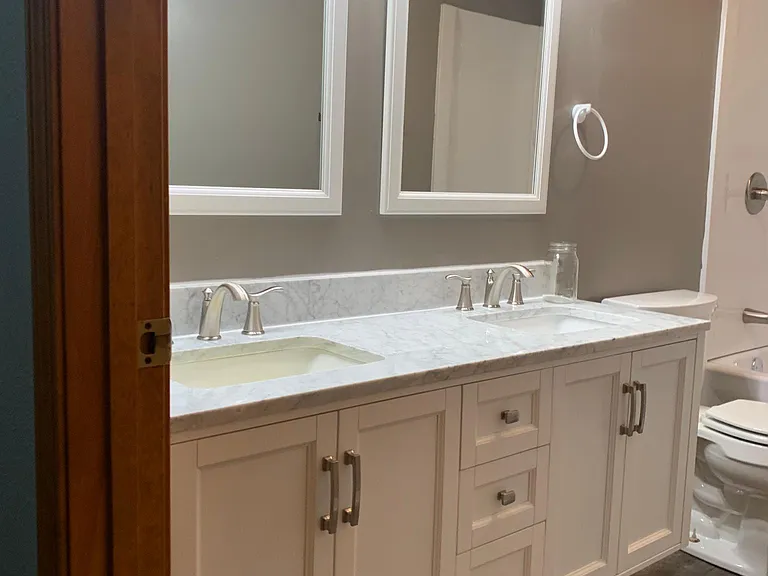 Main bathroom with the double vanity and sinks features LED lighting