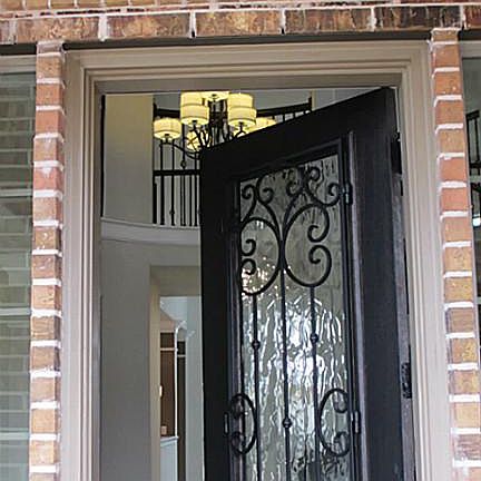 Inviting entry with solid wood and wrought iron front door that leads you into your new home!