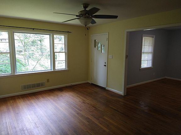 View of living room looking towards front door and front room with built in cabinets