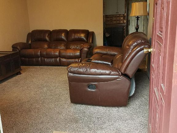 Living area view from front door with storm door and nice ca