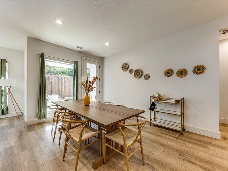 Dining area featuring light wood-finish flooring, recessed lighting, and a modern dining table