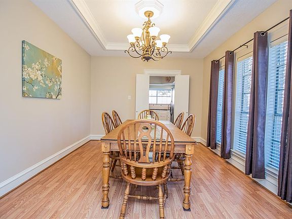 Upon entering, the dining room sits to the right. Large sun-filled windows, elegant rubbed bronze chandelier, tres ceiling, new engineered wood flooring, thick baseboards and crown molding.