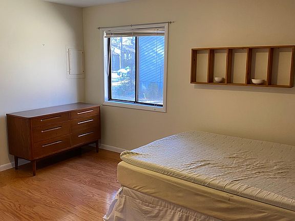 2nd bedroom that faces grassy area and is considered the master bedroom with its own entrance into bathroom and can be made darker for those that need it dark to sleep. One gray wall and the rest white. Two closets that are smaller. Both bedrooms similar