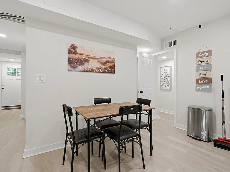 Dedicated dining area with a four-seat table, open flow to adjacent spaces, and durable flooring for easy upkeep.