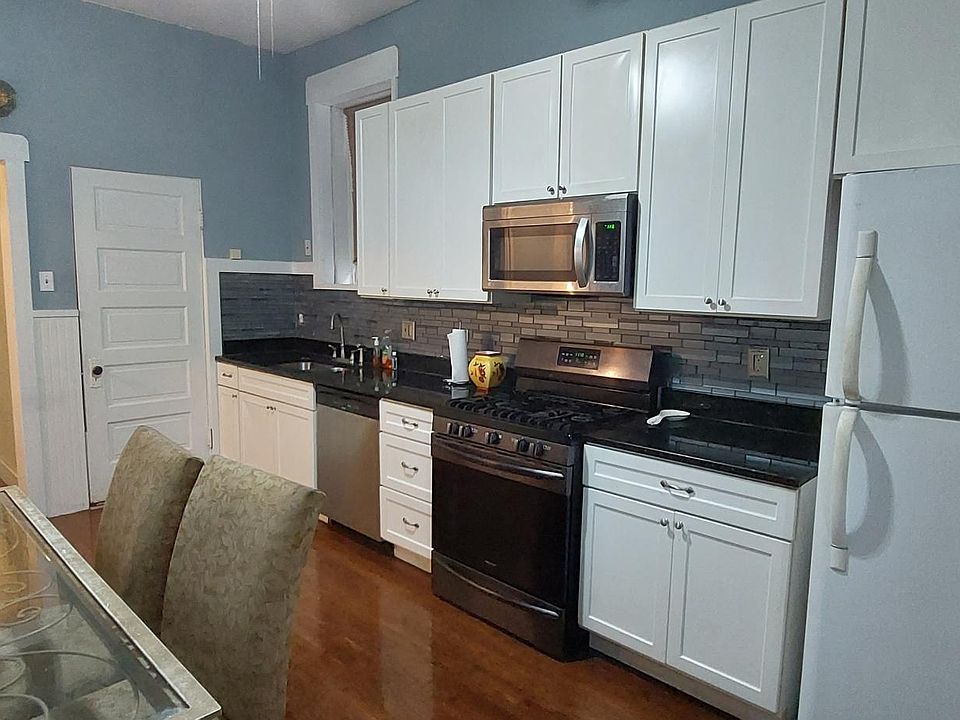 Large kitchen with dishwasher, stove and refrigerator. Dining table stays.