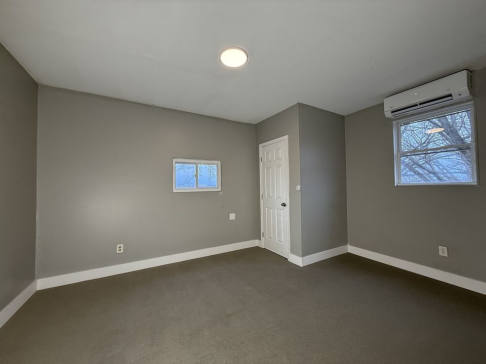 Cozy and versatile, with soft carpet, fresh paint, and great natural light from a large window.