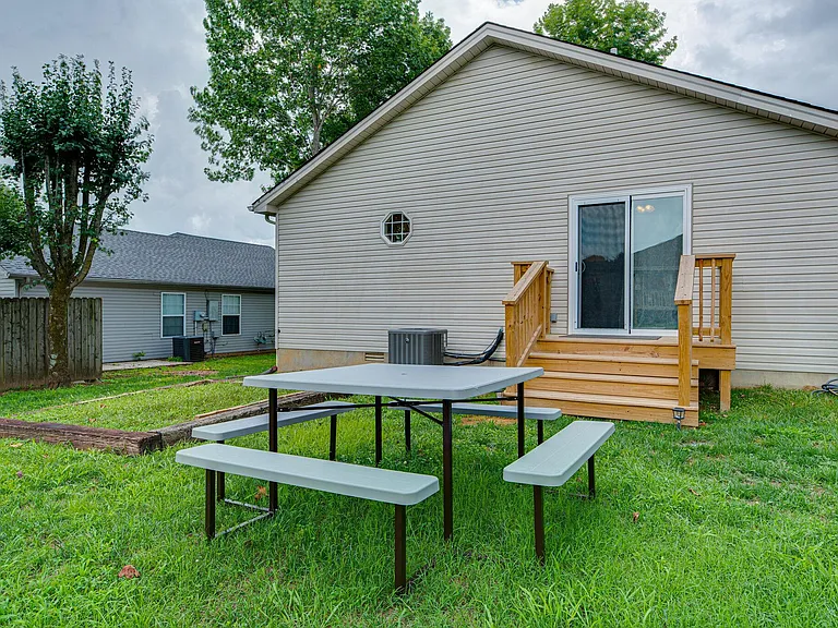 Large open backyard with picnic table and small decking to welcome the day