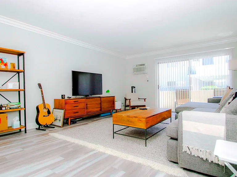 Living room with hardwood floor and large patio windows.