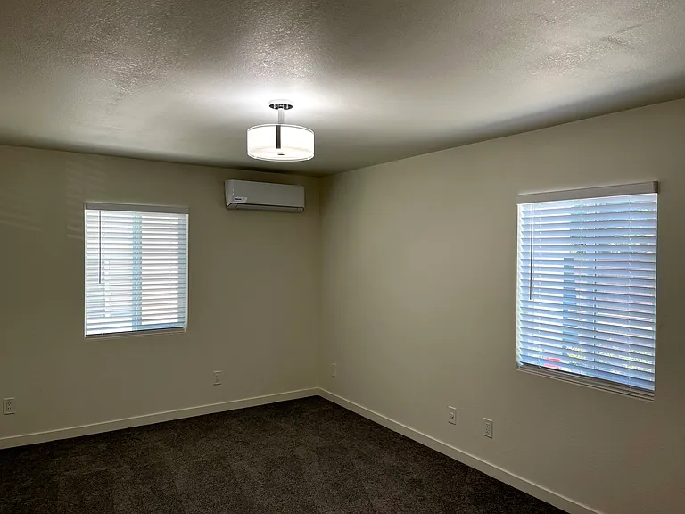Bedroom #2 with large space, windows and plush carpet.