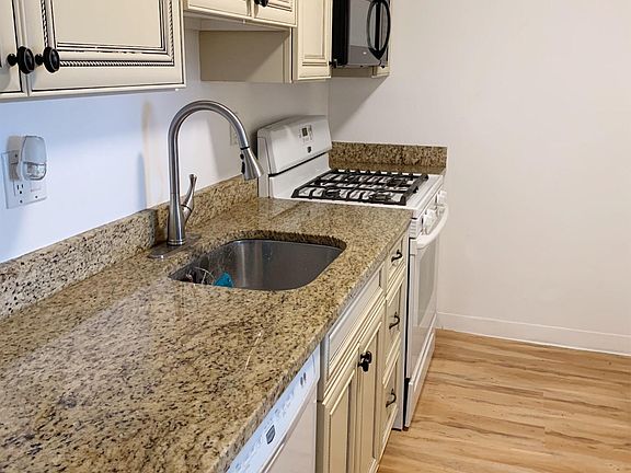 Kitchen with granite countertops, gas range & dishwasher.