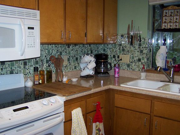 Kitchen with new counter tops, knobs, stove, microwave, paint, and glass tile 