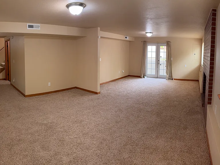 Bottom living area with patio access to front of house.